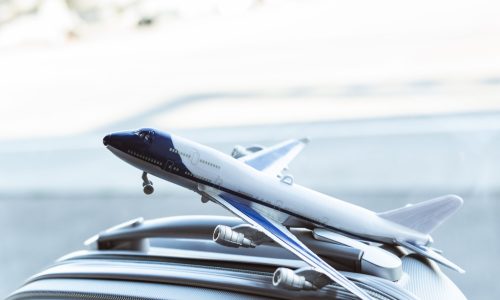 close up of small plane model on grey suitcase in airport